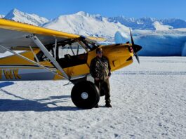 Scott Ogan on a glacier landing with a plane, Alaska, USA.